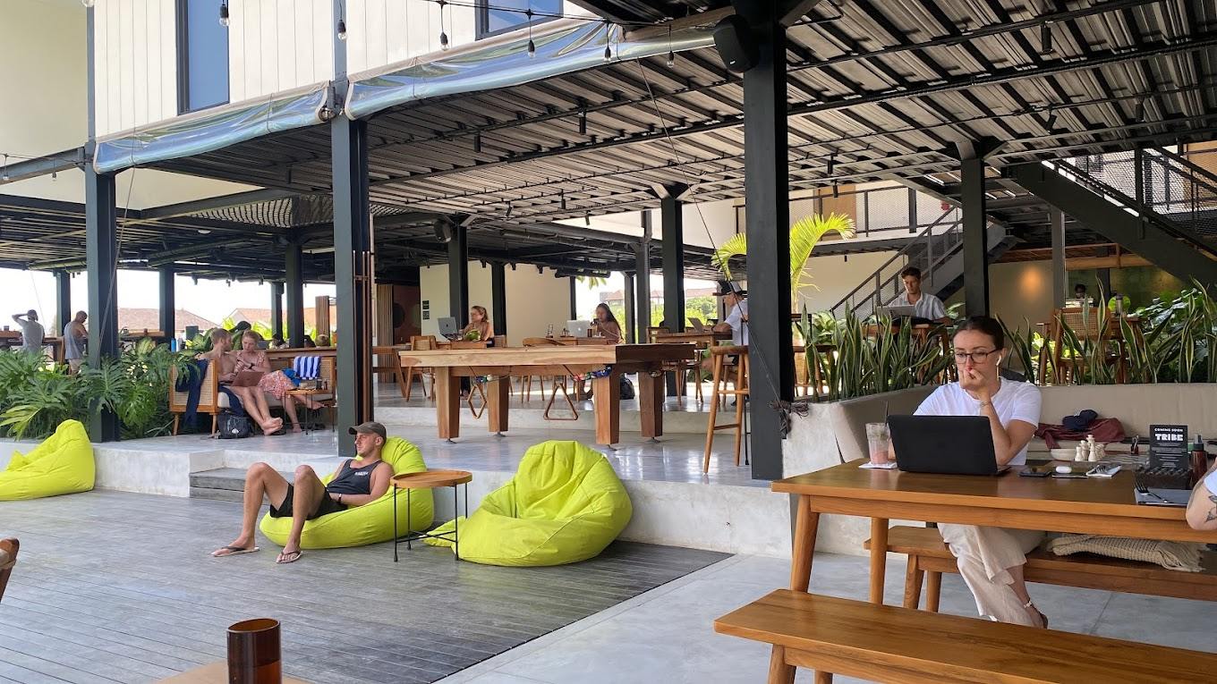 Foreign professionals working on laptops in an open-air co-working cafe in Bali