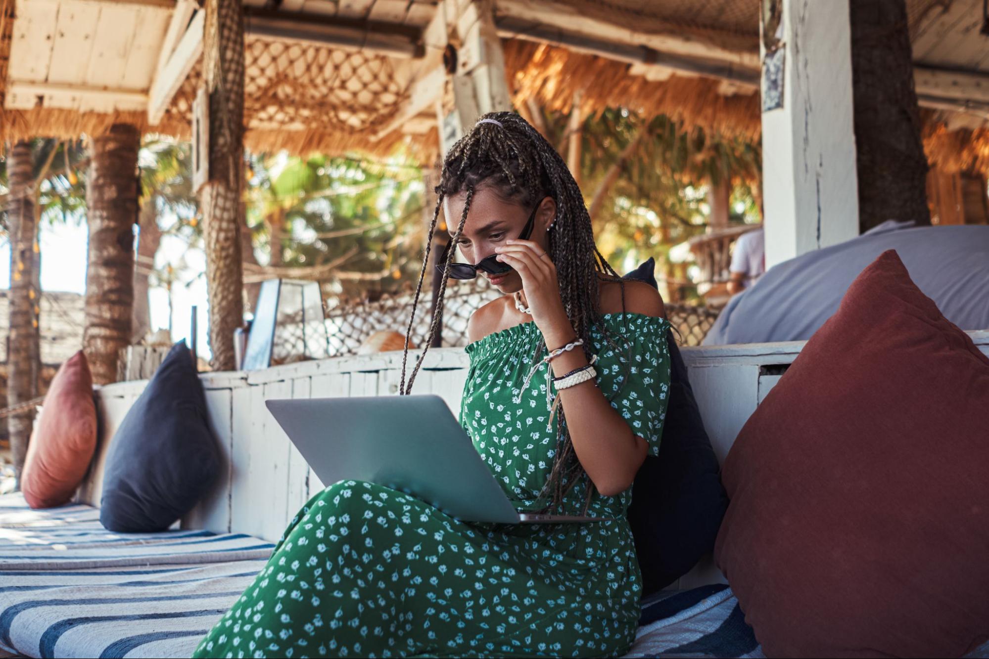 Remote worker using a laptop at a beach bar in Bali on an E33G visa — an alternative to the Indonesia work visa for Australians